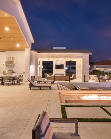 Outdoor kitchen, fire pit, and pool at a Scottsdale vacation home at night