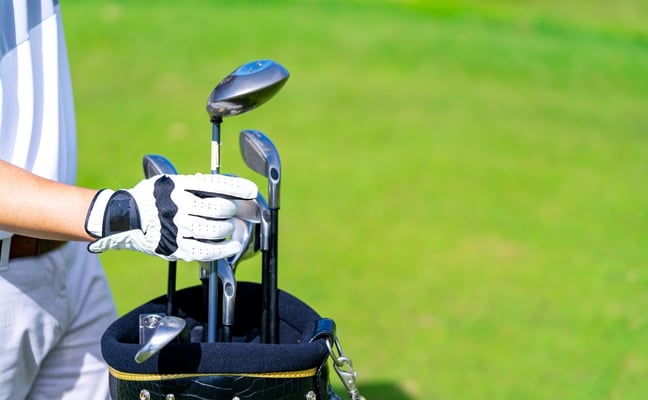 Golfer selecting a club from a bag on the fairway